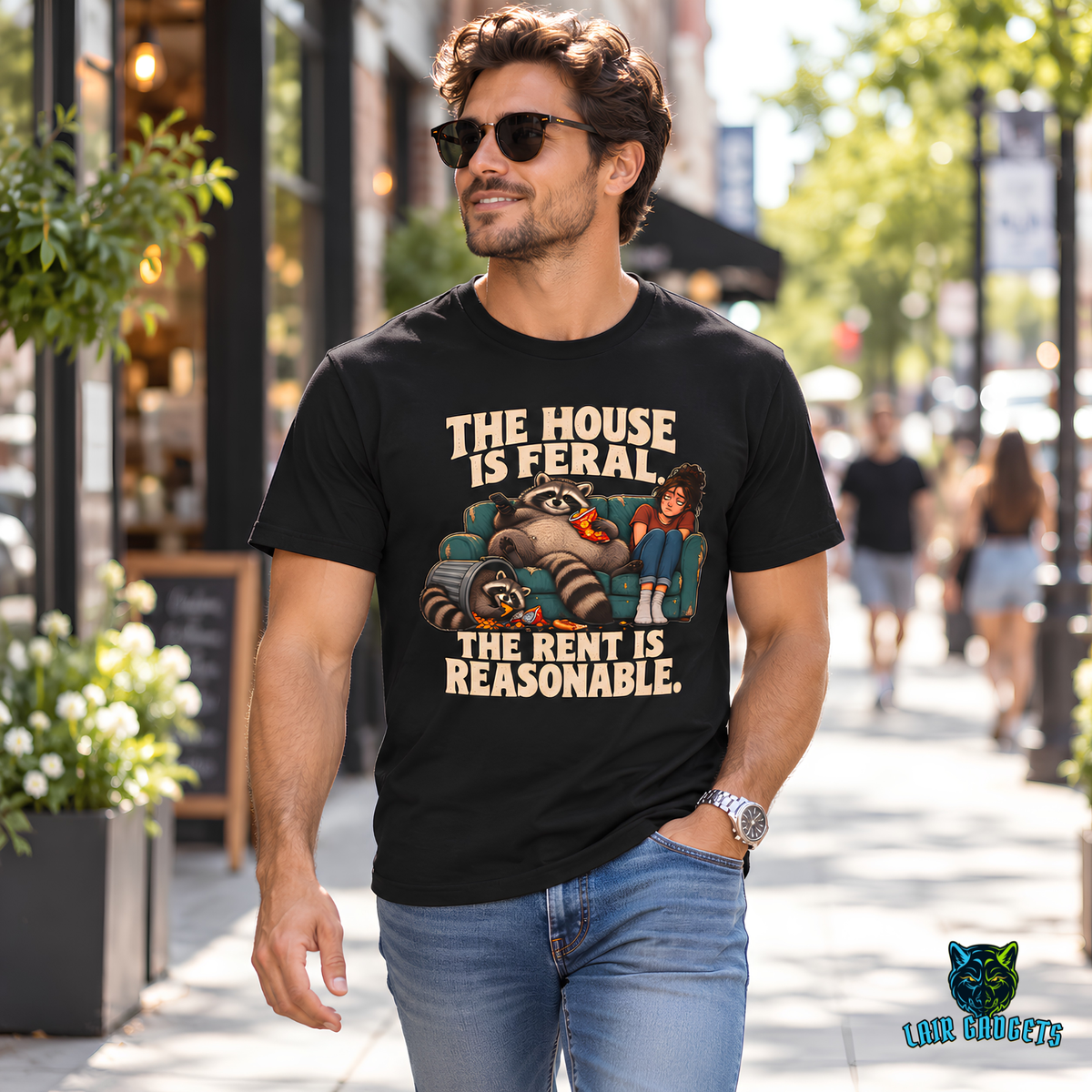 Model in a black tee reading The House Is Feral. The Rent Is Reasonable. with raccoons on a couch beside a woman